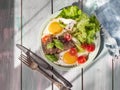 Hot breakfast of scrambled eggs, leaf lettuce, cherry tomatoes and grilled beef liver