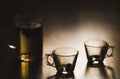 Hot brewed tea in transparent teapot and two cups on wooden background