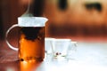 Hot brewed tea in transparent teapot and two cups on wooden background Royalty Free Stock Photo