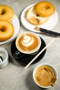 Hot Butterscotch Latte Art Coffee served in cup with plain donuts, sugar and knife isolated on napkin side view cafe breakfast