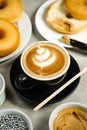 Hot Butterscotch Latte Art Coffee served in cup with plain donuts, sugar and knife isolated on napkin side view cafe breakfast