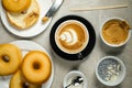 Hot Butterscotch Latte Art Coffee served in cup with plain donuts, sugar and knife isolated on napkin top view cafe breakfast