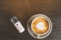 Hot cappuccino coffee with alcohol nano mist sprayer for patients quarantined by Corona virus Covid-19 outbreak on the wooden Royalty Free Stock Photo