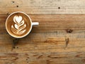 Hot cappuccino coffee flower latte art on brown retro wood table Royalty Free Stock Photo