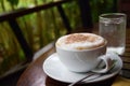 Hot cappuccino and cold water on wod table Royalty Free Stock Photo