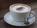 Hot cappuccino with full fine bubble cream little cacao powder served in white ceramic coffee cup Royalty Free Stock Photo