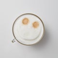 A cup of fragrant cappuccino with a smile face on a gray background with a copy of the space. Top view