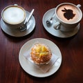 Hot cappuccino and latte coffee and muffin on a table