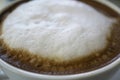 Close up shot of the cup of the hot cappucino on top with milk foam. Royalty Free Stock Photo