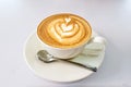 Hot Cappuccino in white cup on white saucer with silver spoon Royalty Free Stock Photo