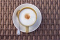 Hot capuchino coffee in a ceramic cup on bamboo wooden table. Top view Royalty Free Stock Photo