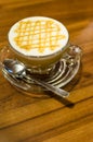 Hot caramel coffee macchiato and white milk foam in glass with s