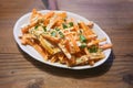 Hot carrot strips with a creamy spicy dressing and parsley garnish, healthy cold tapa snack for a Mediterranean buffet on a rustic