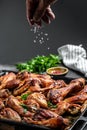 Hot Chicken wings and legs with celery, Cook hand sprinkling salad with meat in a freeze motion. Food recipe background. Close up Royalty Free Stock Photo
