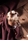 Hot chocolate with cinnamon and marshmallow on wooden background with chocolate sweets