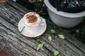 Hot chocolate or coffee with foam milk in white cup on Timber and green leave Background blurry views tree .Christmas Holiday conc