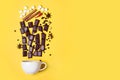 Hot chocolate cup, chocolate pieces, spices and marshmallows on yellow background