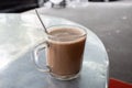 A hot chocolate malt beverage on an aluminium table. It is a typical Malaysian morning drink for energy and power