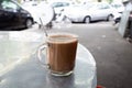 A hot chocolate malt beverage on an aluminium table. It is a typical Malaysian morning drink for energy and power