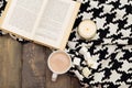 Hot chocolate, marshmallow, open book and candle on a wooden background. View from above Royalty Free Stock Photo