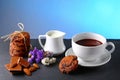 Hot chocolate and milk, cup of cocoa, chocolate cookies, almonds, flowers on a shale board on bright blue background, place to cop Royalty Free Stock Photo