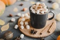 Hot chocolate with mini marshmallows, cinnamon, star anise and cocoa powder served in a black mug Royalty Free Stock Photo