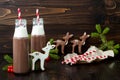 Hot chocolate with whipped cream in old-fashioned retro bottles with red striped straws. Christmas holiday drink and gingerbread Royalty Free Stock Photo