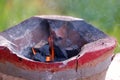 Hot coals in a brazier to prepare for cooking in outdoor space with smoke