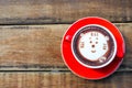 Hot cocoa and face cat milk foam in the red cup on wood background Royalty Free Stock Photo