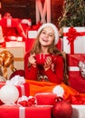 Hot cocoa. Gifts shop. Kid santa hat christmas gift boxes. Child little happy girl find gifts near christmas tree. Merry