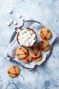 Hot cocoa with marshmallow in ceramic mug surrounded by Christmas gingerbread. Decorated red nosed reindeer cookies. Royalty Free Stock Photo