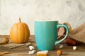 Hot cocoa with marshmallows in a blue ceramic mug with autumn leaves and pumpkins on a wooden table. The concept of hygge, cozy Royalty Free Stock Photo