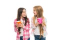 Hot cocoa recipe. Make sure kids drink enough water. Girls kids hold cups white background. Sisters hold mugs. Drinking