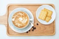 Hot coffee on background served with crackers on white plate. on top