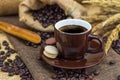 Hot coffee in brown cup with beans, saucer and macarons Royalty Free Stock Photo