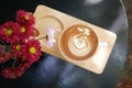 Hot coffee cappuccino latte art swan bird foam on wooden plate with flowers top view background. Royalty Free Stock Photo
