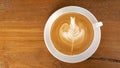 Hot coffee cappuccino latte art top view on wooden background Royalty Free Stock Photo