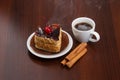 Hot coffee with cinnamon sticks and cake on a plate Royalty Free Stock Photo