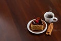 Hot coffee with cinnamon sticks and cake on a plate Royalty Free Stock Photo