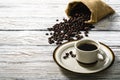 Hot coffee in a coffee cup and coffee beans placed around on an old wooden table in a warm, light atmosphere, on old white wood Royalty Free Stock Photo