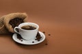 Hot coffee cup and coffee beans in burlap bag Royalty Free Stock Photo