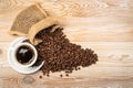 Hot coffee cup and coffee beans in burlap bag