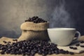 Hot coffee cup and beans in a sack. Royalty Free Stock Photo