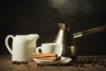 Hot coffee cup with cinnamon sticks with a creamer and old pot/hot coffee cup with cinnamon sticks with a creamer and old pot on a Royalty Free Stock Photo