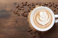 Hot coffee in a cup with foam milk beautiful latte art and coffee beans on wooden table, ai generative Royalty Free Stock Photo