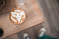 Hot coffee cup of latte art, coffee on wooden table in the morning. Top view with  of people on jeans Royalty Free Stock Photo