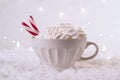 Hot Coffee cup with marshmallows and red candy cane on a frosty winter background. Christmas holidays background. Royalty Free Stock Photo