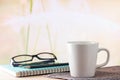 Hot coffee cup in morning light on the wooden table and nature background with copy space