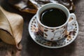 Hot coffee in the cup on old wood table with leaf Royalty Free Stock Photo