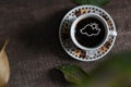 Hot coffee in the cup on old wood table with leaf Royalty Free Stock Photo